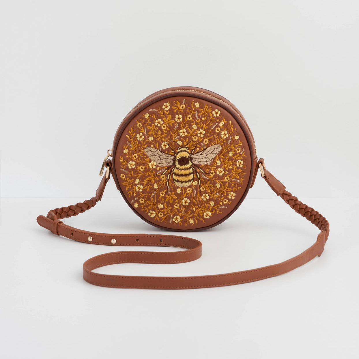 Round brown bag with floral pattern and bee design on a white background