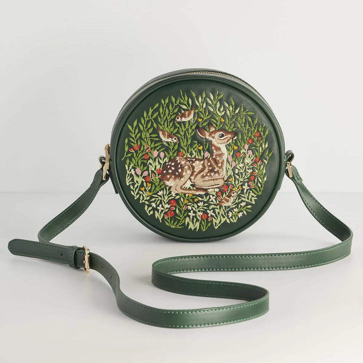 Round green handbag with deer and floral design on a white background