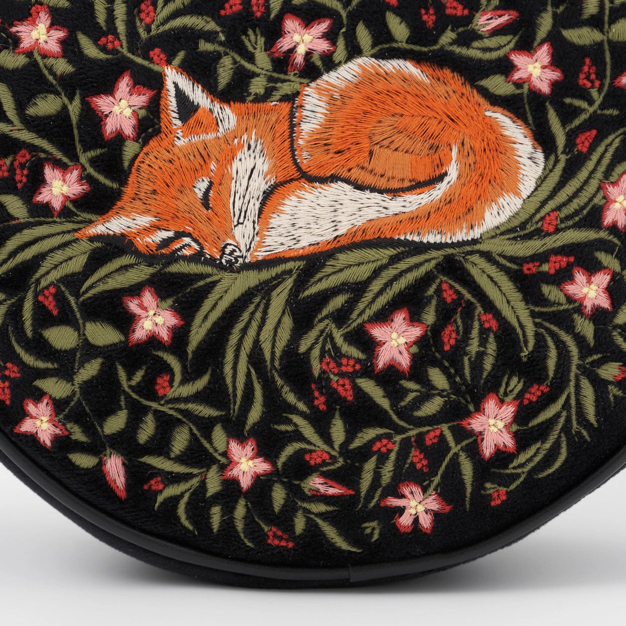 Embroidered fox design on a black background with pink flowers
