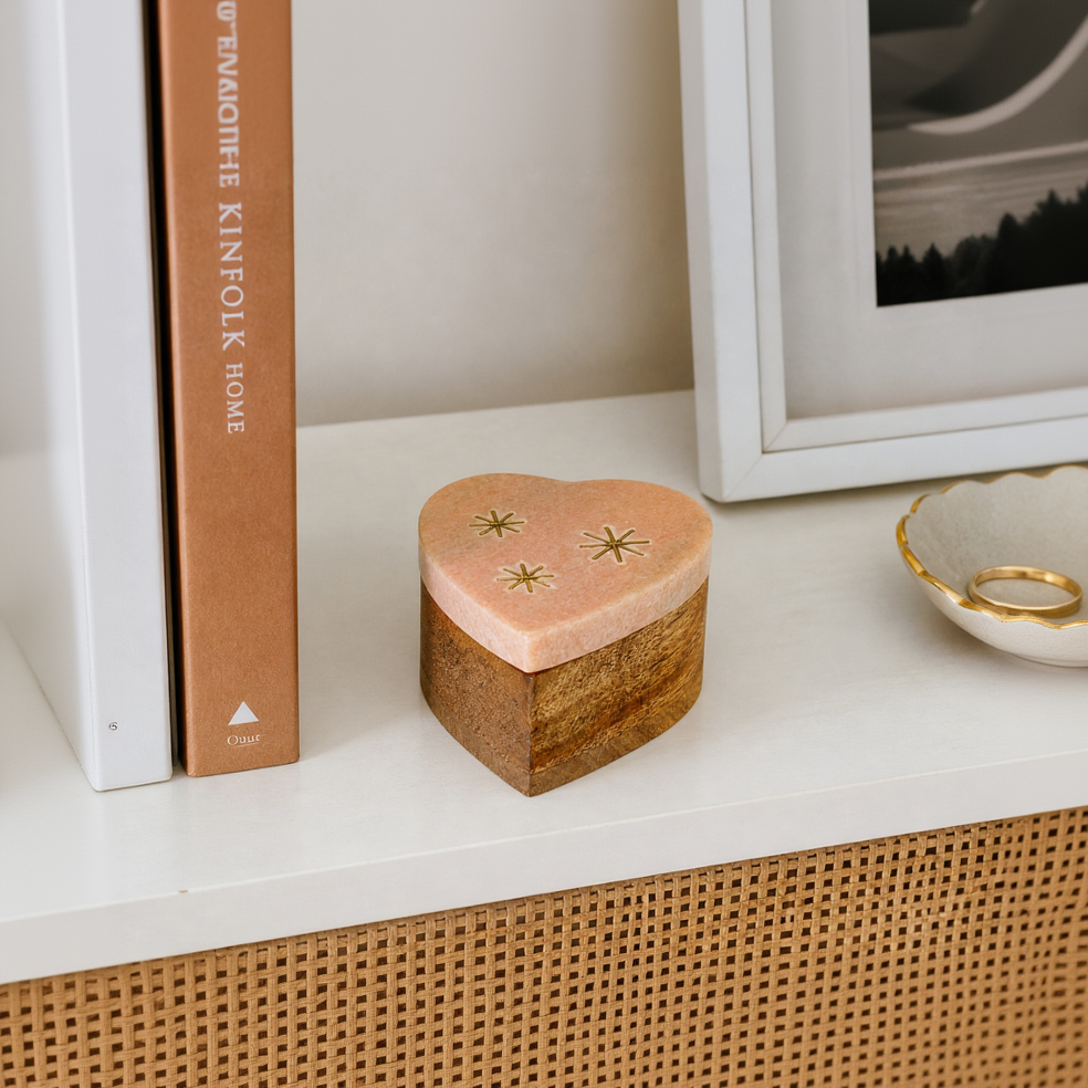 Heart-shaped wooden box on a shelf with books and a framed picture in the background