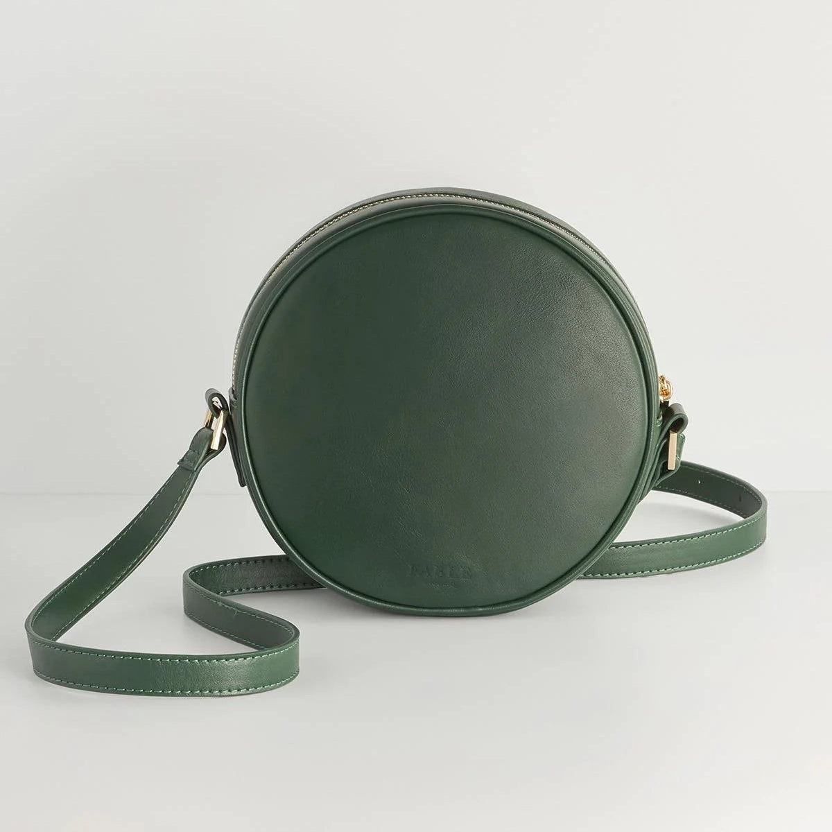 Green round crossbody bag on a light gray background