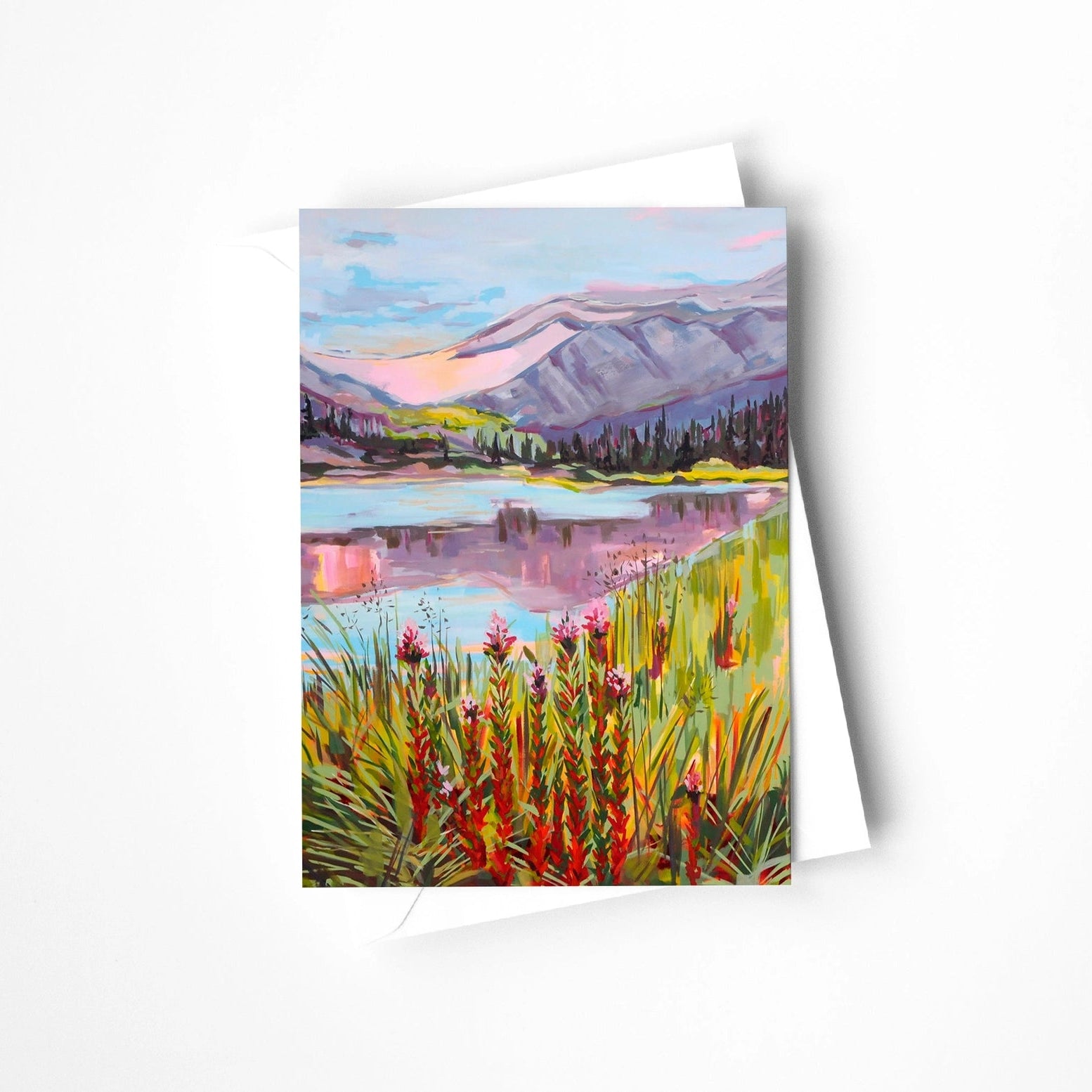 Greeting card with a painting of a mountain landscape and lake on a white background